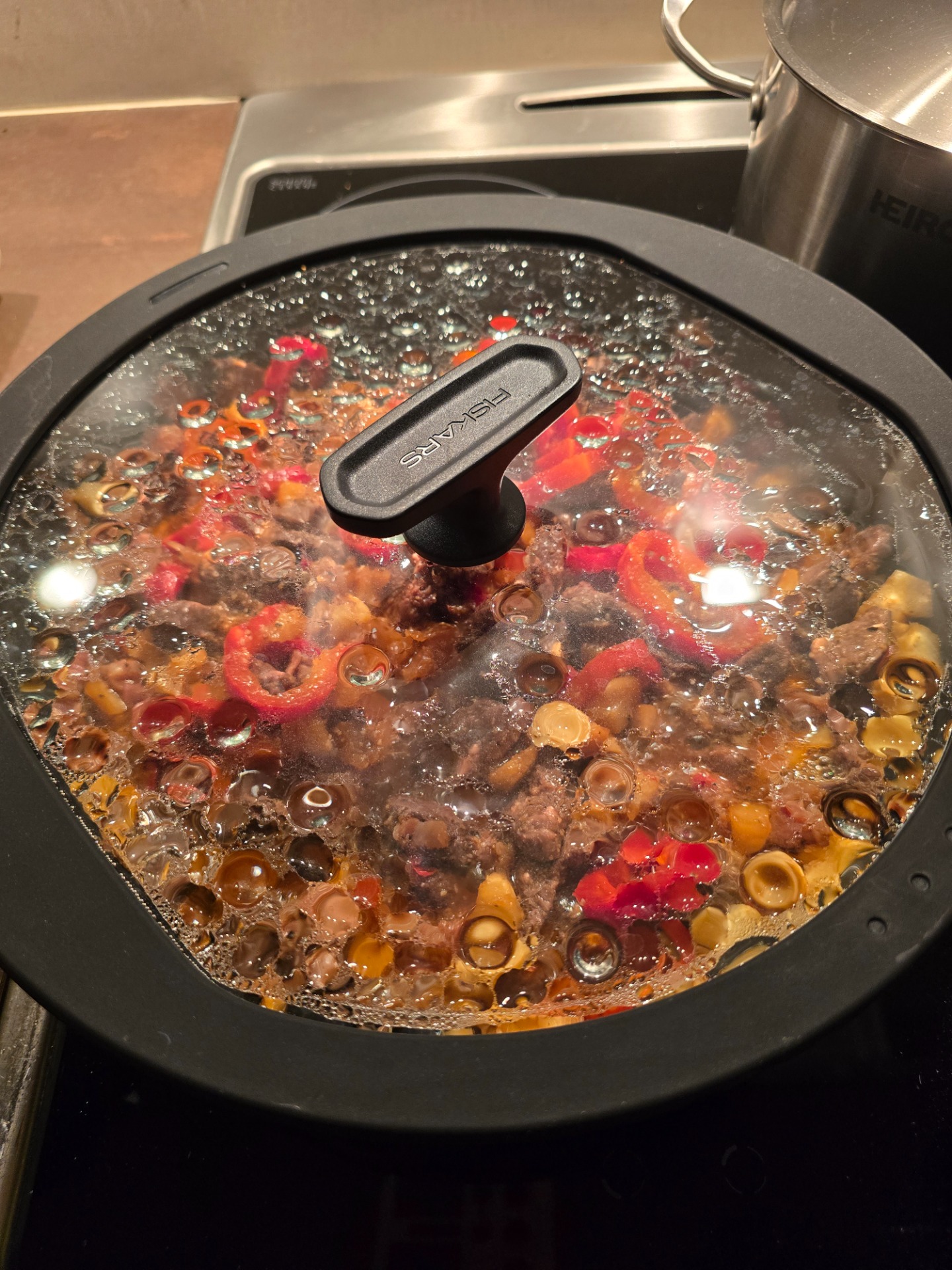 Liha-kasvispata porisee liedellä odottaen risoton kypsymistä.